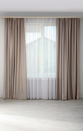 Window with elegant curtains in empty room