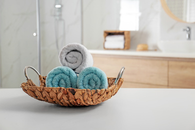 Wicker tray with clean soft towels in bathroom. Space for text