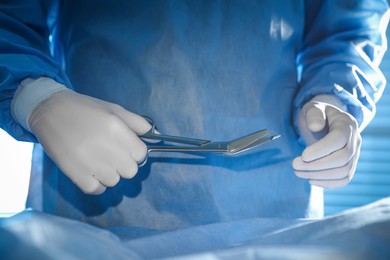 Professional surgeon with instruments performing operation in clinic, closeup