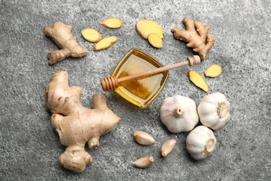 Ginger and other natural cold remedies on grey table, flat lay