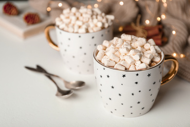 Delicious cocoa drink with marshmallows on white table, space for text