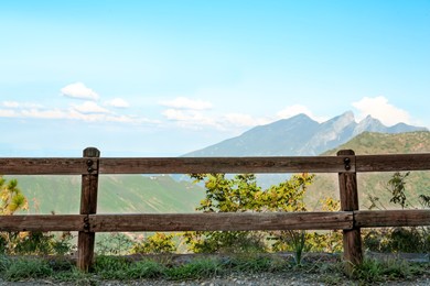 Wooden fence near beautiful big mountains under blue sky