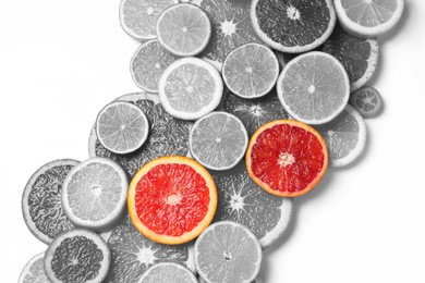 Fresh citrus fruits on light background, flat lay. Black and white tone with selective color effect