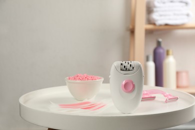 Photo of Set of epilation products on white table in bathroom