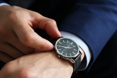 Businessman in jacket with luxury wrist watch, closeup