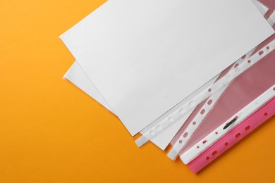 Photo of File folder with punched pockets on orange background, flat lay. Space for text