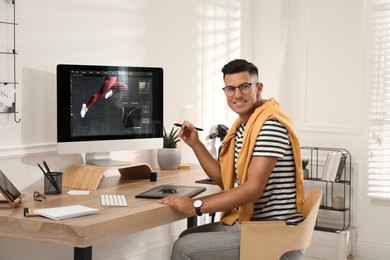 Professional retoucher working on graphic tablet at desk in office