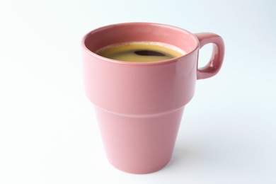 Pink mug of freshly brewed hot coffee on white background