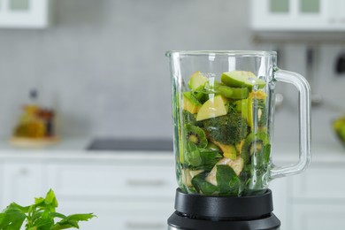 Photo of Blender with ingredients for smoothie in kitchen. Space for text