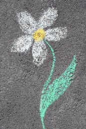 Flower drawn with colorful chalks on asphalt outdoors, top view