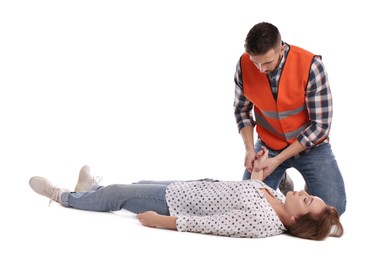 Paramedic in uniform performing first aid on unconscious woman against white background
