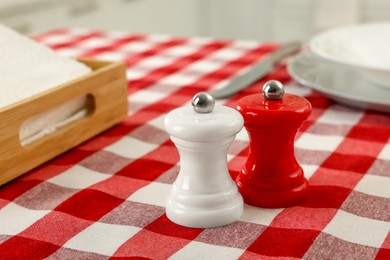 Ceramic salt and pepper mills on kitchen table. Space for text