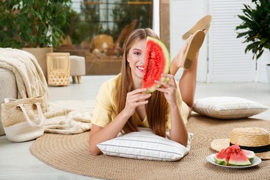 Beautiful teenage girl with slice of watermelon at home