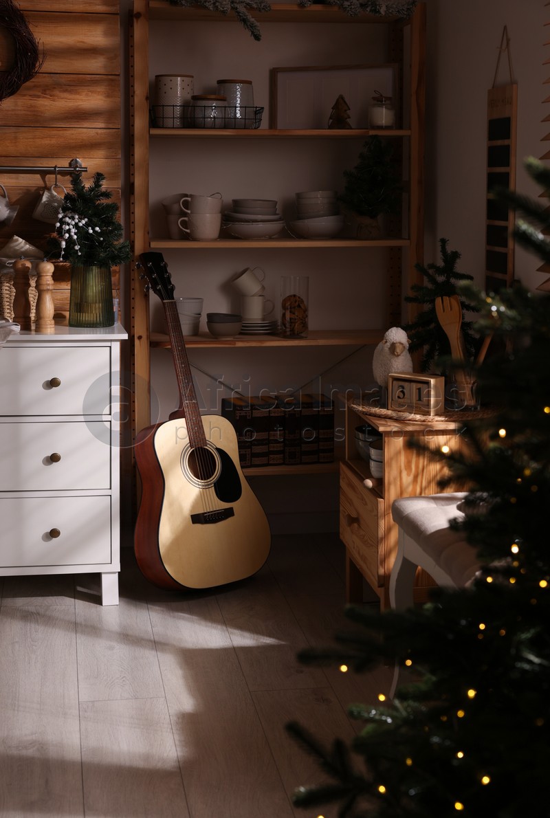 Stylish kitchen interior with Christmas tree and guitar