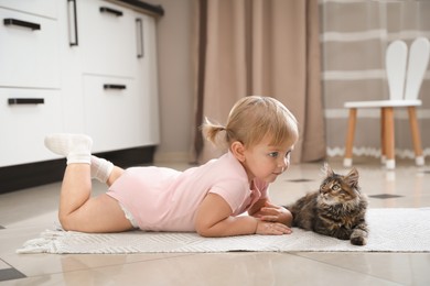 Photo of Cute little child with adorable pet on floor at home