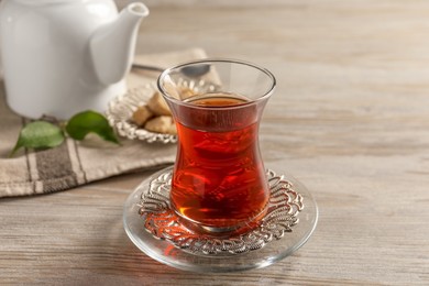 Glass of traditional Turkish tea on white wooden table, closeup