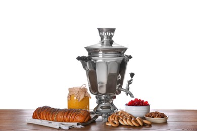 Traditional Russian samovar and treats on wooden table against white background