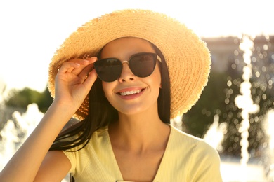 Photo of Beautiful young woman wearing stylish sunglasses outdoors