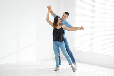 Beautiful young couple dancing in empty studio