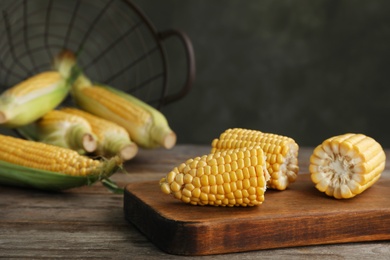 Tasty sweet corn cob on wooden board