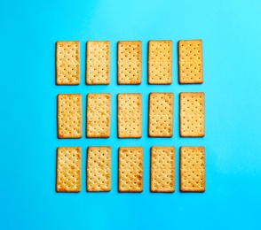 Delicious crackers on light blue background, flat lay