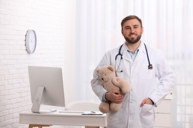 Photo of Pediatrician with teddy bear and stethoscope in clinic