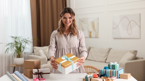 Young woman with beautiful gifts in living room