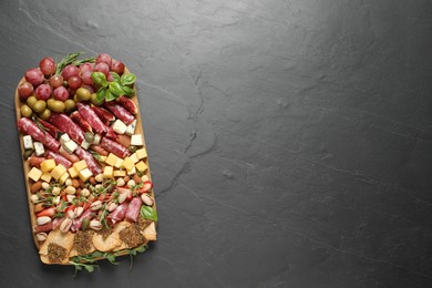 Photo of Different tasty appetizers on dark grey table, top view. Space for text