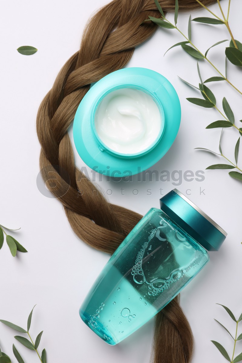 Natural cosmetic products, green leaves and hair braid on white background, flat lay