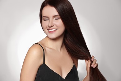 Photo of Beautiful young woman with healthy strong hair posing in studio