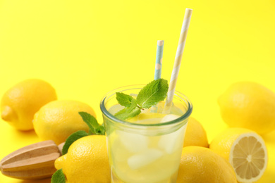 Natural freshly made lemonade on yellow background, closeup. Summer refreshing drink