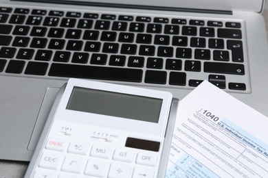 Calculator, document and laptop on table, closeup. Tax accounting
