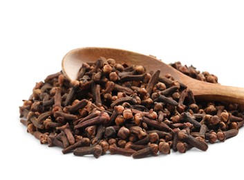 Pile of aromatic dry cloves and wooden spoon on white background, closeup