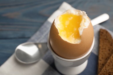 Holder with soft boiled egg on table, closeup. Space for text