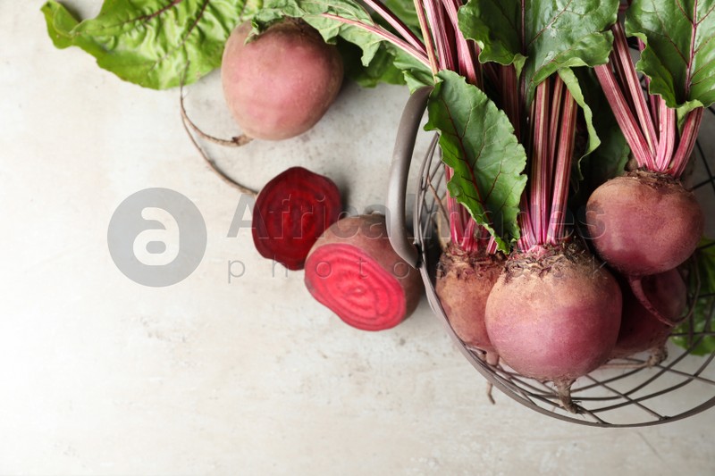 Flat lay composition with fresh red beets on light table, space for text