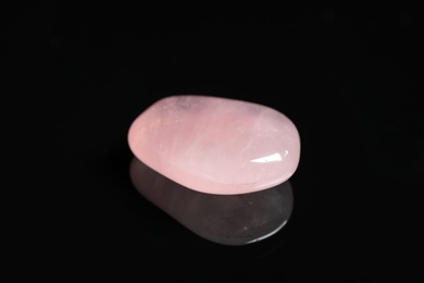 Photo of Beautiful pink quartz gemstone on black background