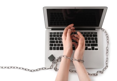Woman showing hands chained to laptop on white background, top view. Internet addiction