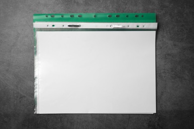 Photo of File folder with punched pockets on grey table, top view. Space for text