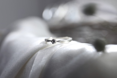 Beautiful engagement ring on wedding dress, closeup