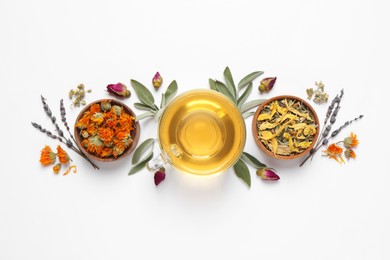 Freshly brewed tea and dried herbs on white background, top view