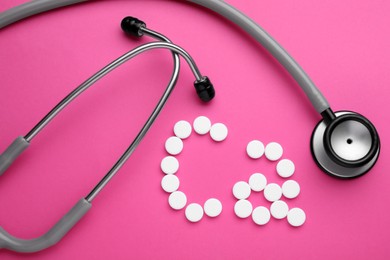 Photo of Stethoscope and calcium symbol made of white pills on bright pink background, flat lay