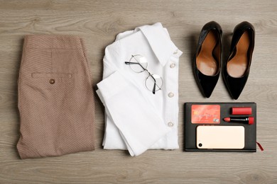 Flat lay composition with clothes, shoes and accessories on wooden background. Packing for business trip