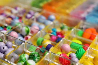 Organizer with variety of colorful beads as background, closeup