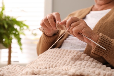 Elderly woman knitting at home, closeup. Creative hobby