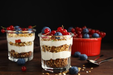 Delicious yogurt parfait with fresh berries on wooden table