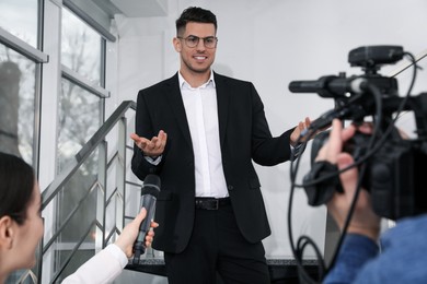 Photo of Happy business man talking to journalists indoors