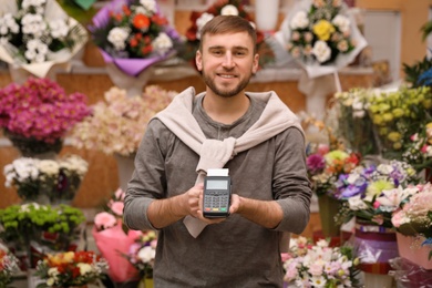 Photo of Seller holding payment terminal in floral shop