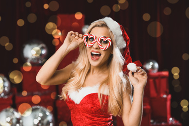 Beautiful young woman in Christmas costume against blurred lights