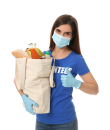 Female volunteer in protective mask and gloves with products on white background. Aid during coronavirus quarantine