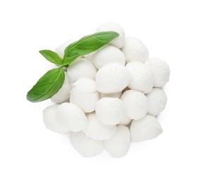 Pile of mozzarella cheese balls and basil on white background, top view